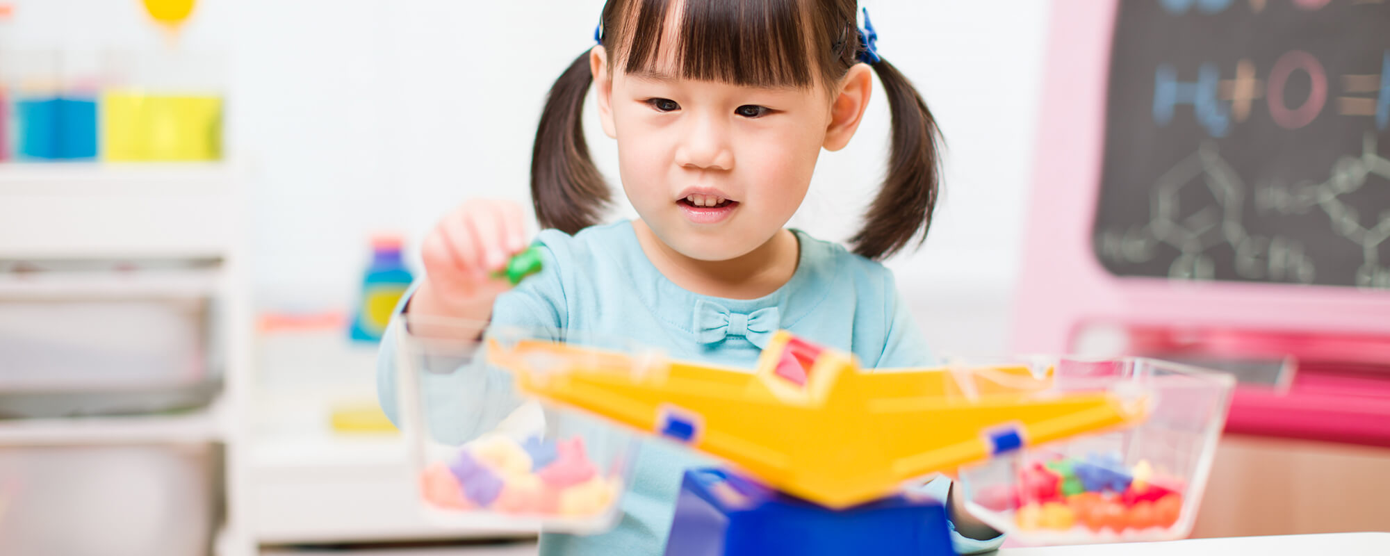A girl plays with a toy scale.